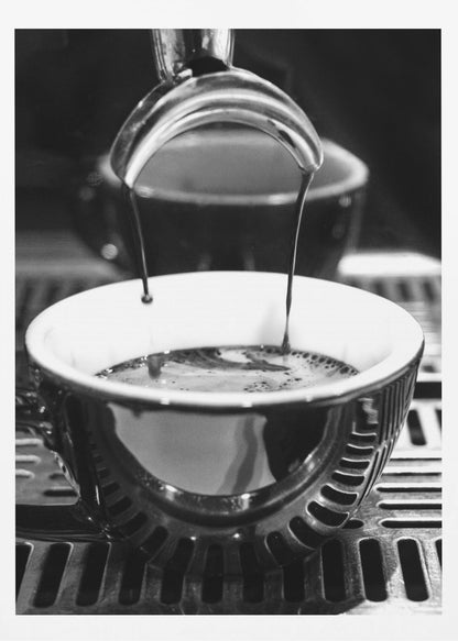 A close-up, black and white artistic photograph capturing the moment two streams of dark espresso pour from a portafilter into a waiting cup on a coffee machine's drip tray. Wall Art