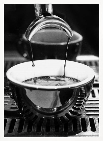 A close-up, black and white artistic photograph capturing the moment two streams of dark espresso pour from a portafilter into a waiting cup on a coffee machine's drip tray. Wall Art