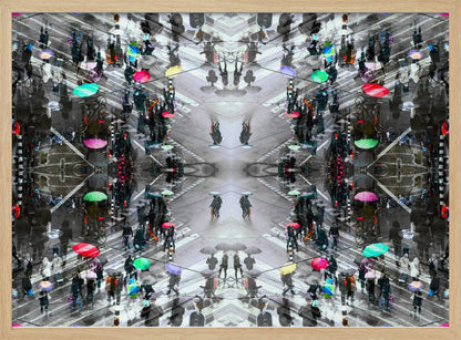 A symmetrical, kaleidoscopic abstract artwork created from an aerial view of a rainy city intersection. The mostly black and white image features pops of vibrant color from numerous umbrellas held by pedestrians crossing the street, all framed in a textured silver border. Artwork