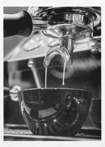 A close-up, black and white photograph of an espresso machine pouring two streams of fresh coffee from a chrome portafilter into a dark, glossy cup. Print