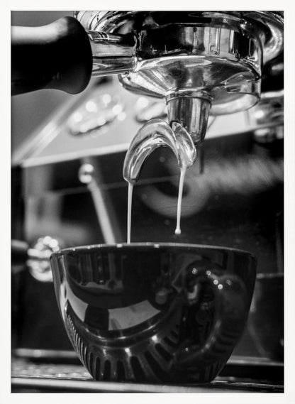 A close-up, black and white photograph of an espresso machine pouring two streams of fresh coffee from a chrome portafilter into a dark, glossy cup. Print