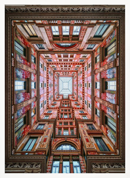A symmetrical, worm's-eye view looking up through the center of an ornate, multi-story courtyard. The red and gold walls are covered in intricate details and frescoes, receding into the distance towards a square glass skylight. The entire artwork is presented within a decorative dark brown frame. Artwork