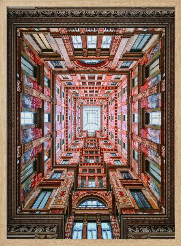 A symmetrical, worm's-eye view looking up through the center of an ornate, multi-story courtyard. The red and gold walls are covered in intricate details and frescoes, receding into the distance towards a square glass skylight. The entire artwork is presented within a decorative dark brown frame. Artwork