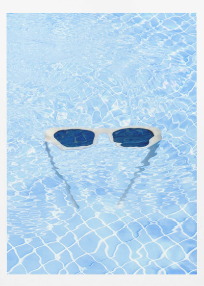 A pair of white-framed sunglasses with dark lenses floats on the surface of a bright blue swimming pool. The rippling water distorts the view of the tiled pool floor, and the sunglasses cast a faint shadow underneath. Print