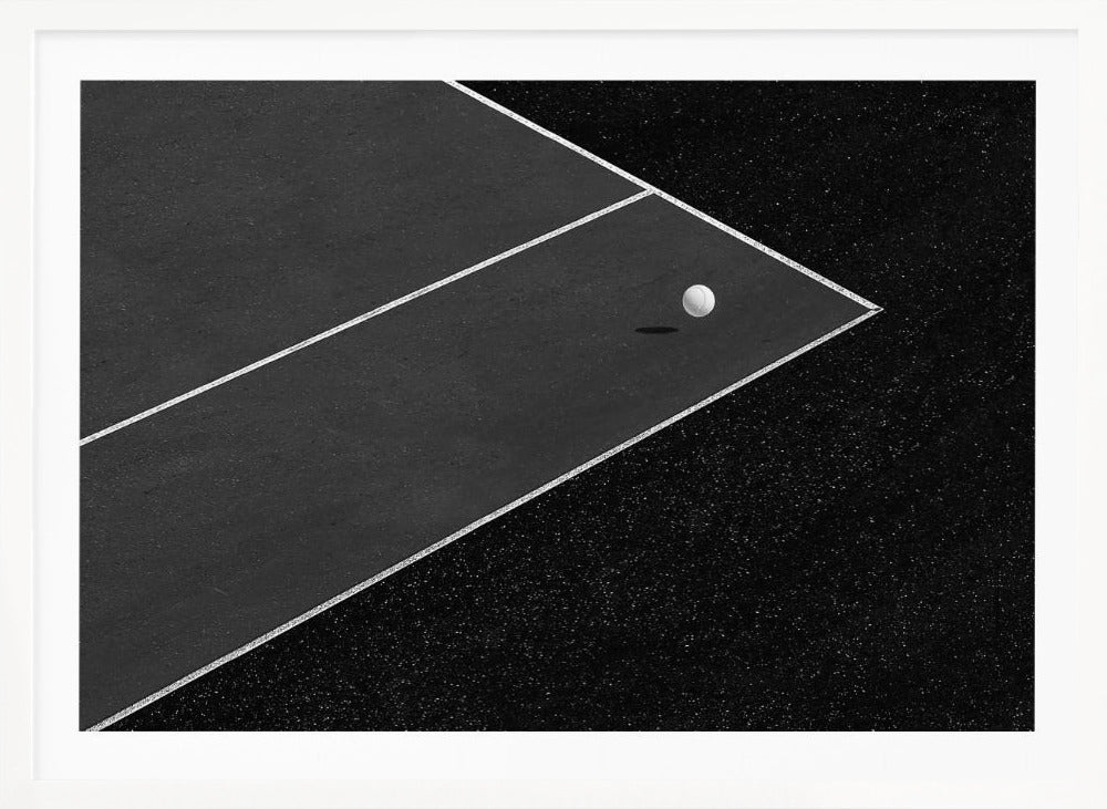 A minimalist black and white overhead photograph of a white ball resting in the corner of a dark tennis or paddle court. The composition focuses on the strong geometric angles created by the white boundary lines against the dark, textured asphalt, all within a silver frame. Artwork