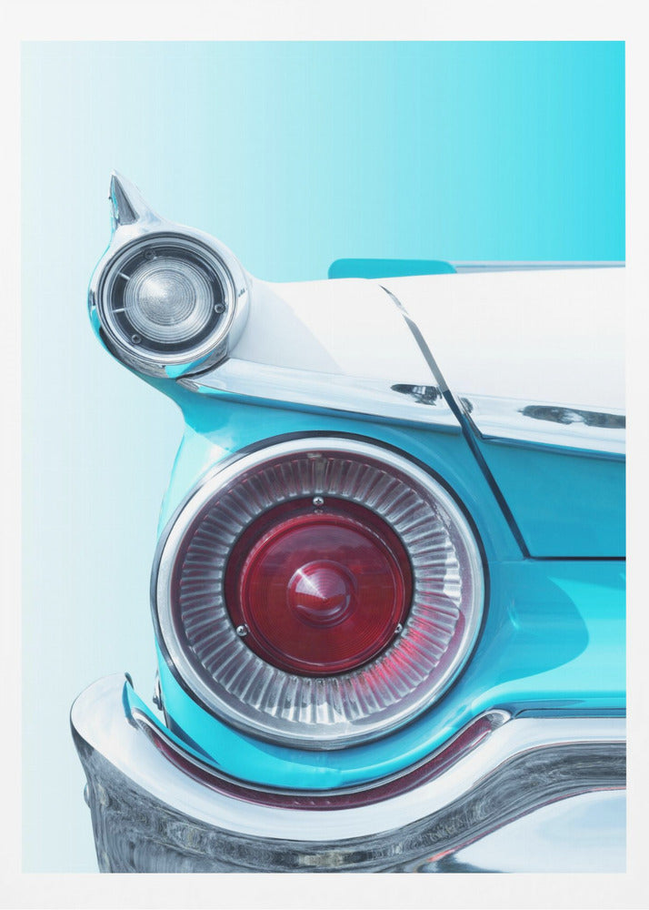 A close-up, framed photograph of the tail fin of a vintage turquoise and white car. The focus is on the large, round, red taillight and the smaller chrome-encased light on the fin, set against a solid light blue background. Poster