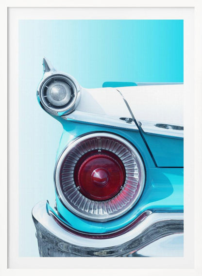 A close-up, framed photograph of the tail fin of a vintage turquoise and white car. The focus is on the large, round, red taillight and the smaller chrome-encased light on the fin, set against a solid light blue background. Poster