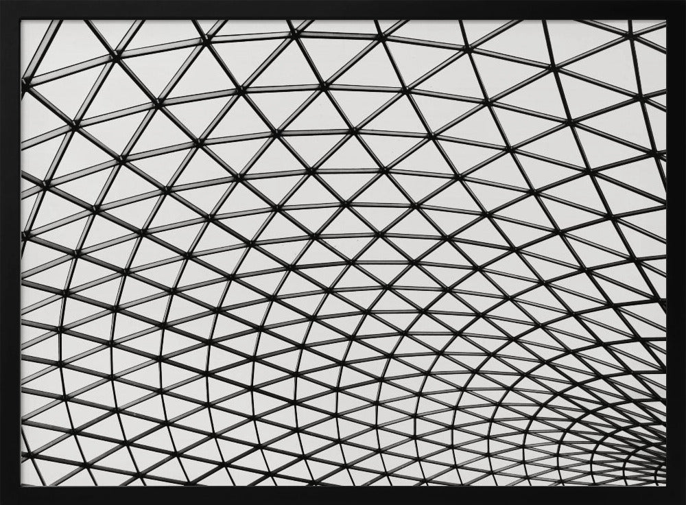 A framed, black and white photograph of a modern architectural dome ceiling. The image is a close-up, looking up at the intricate metal framework that creates a repeating pattern of triangles against the bright glass panels. Poster