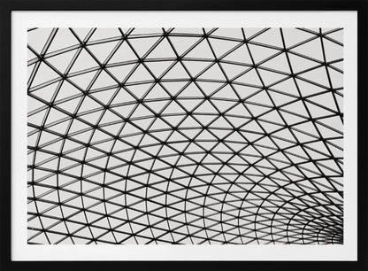 A framed, black and white photograph of a modern architectural dome ceiling. The image is a close-up, looking up at the intricate metal framework that creates a repeating pattern of triangles against the bright glass panels. Poster