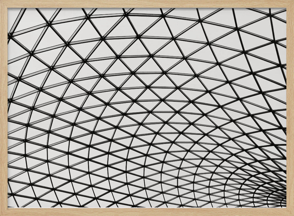 A framed, black and white photograph of a modern architectural dome ceiling. The image is a close-up, looking up at the intricate metal framework that creates a repeating pattern of triangles against the bright glass panels. Poster