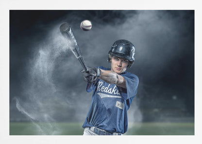 A dramatic, framed portrait of a young baseball player in a blue jersey and helmet, captured in the moment of hitting a baseball, with a cloud of dust exploding from the bat against a dark, smoky background. Poster