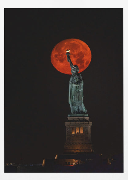 A striking night photograph of the Statue of Liberty perfectly silhouetted against a giant, vibrant red supermoon, which appears to be held aloft by the statue's torch against a deep black sky. Artwork
