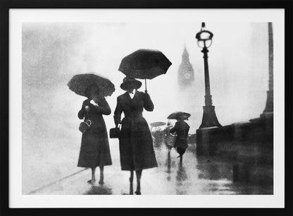 A vintage black and white photograph of people with umbrellas walking on a wet, foggy day in London. The silhouettes of the people are dark against the misty background, where the faint outline of Big Ben and a street lamp are visible. Wall Art