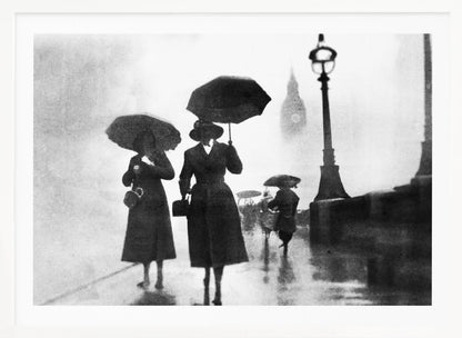 A vintage black and white photograph of people with umbrellas walking on a wet, foggy day in London. The silhouettes of the people are dark against the misty background, where the faint outline of Big Ben and a street lamp are visible. Wall Art