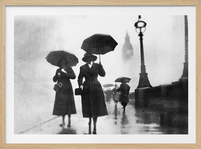 A vintage black and white photograph of people with umbrellas walking on a wet, foggy day in London. The silhouettes of the people are dark against the misty background, where the faint outline of Big Ben and a street lamp are visible. Wall Art