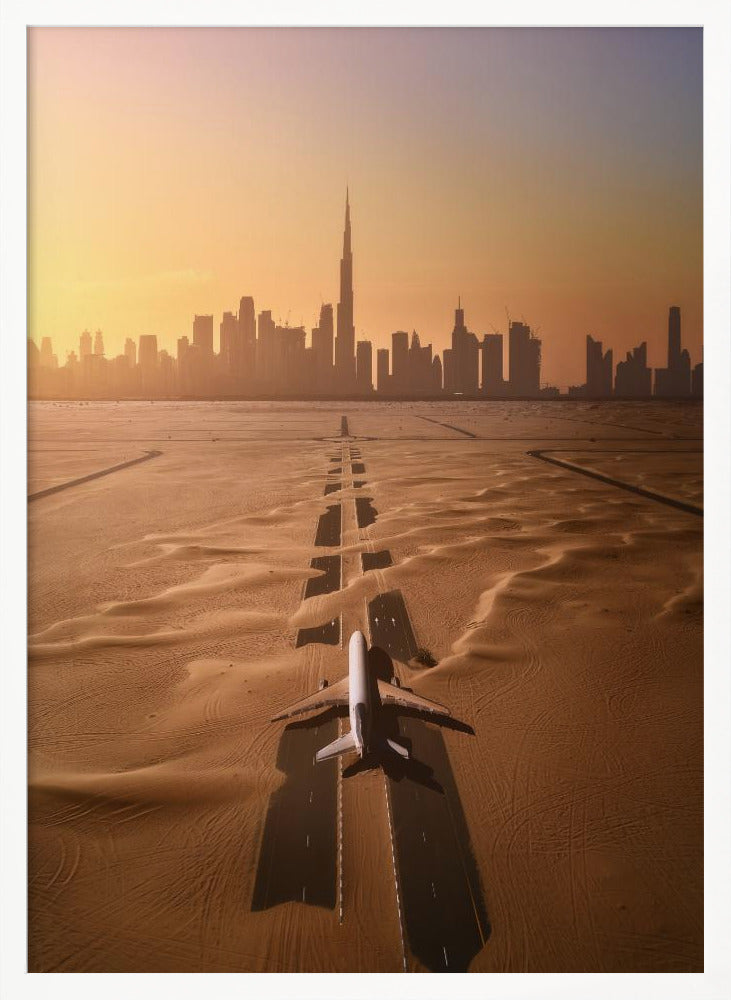 A surreal high-angle view of a white airplane on a runway partially buried in desert sand, pointing towards the Dubai city skyline during a hazy orange sunset. Decor