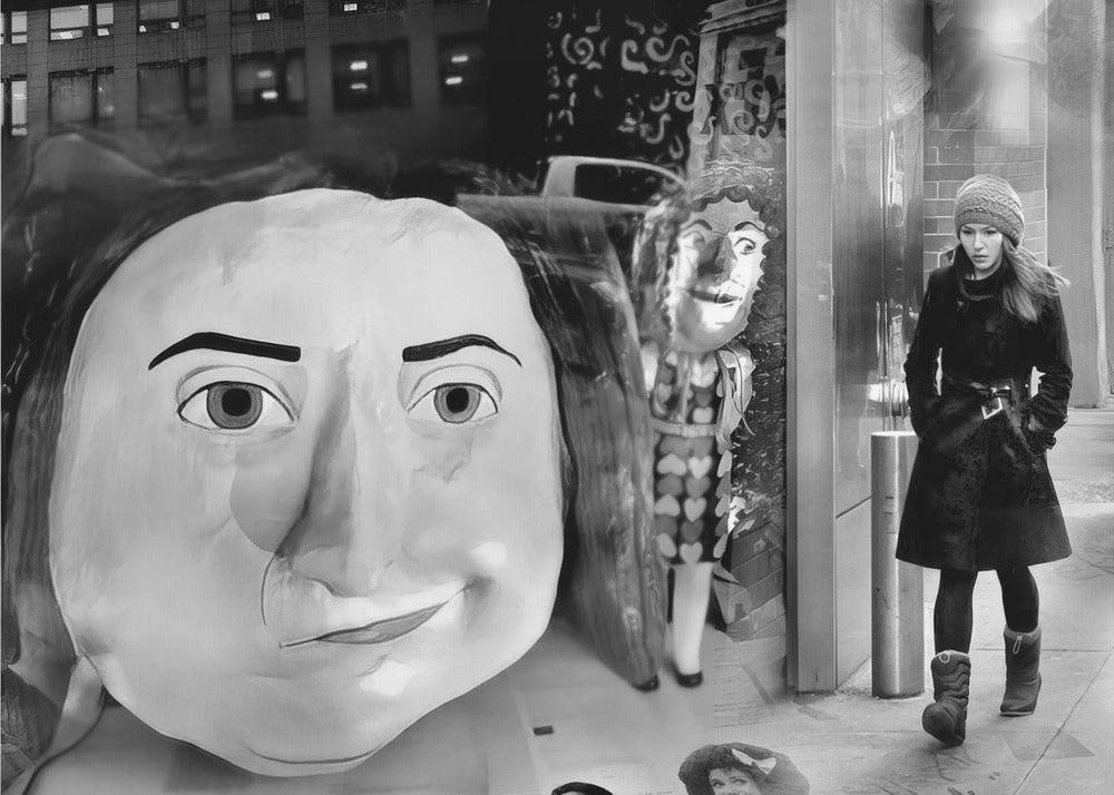 A surreal black and white photograph with a silver frame, featuring a giant, cartoonish head of a historical figure reflected in a window, juxtaposed with a young woman in a winter coat and beanie walking down a city sidewalk. Wall Art