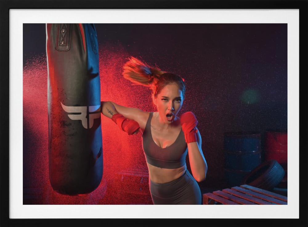 An athletic woman with her hair in a ponytail and red hand wraps fiercely punches a black heavy bag, her mouth open mid-shout. The scene is dramatically lit with red and blue light, and water droplets spray through the air from the impact. Poster