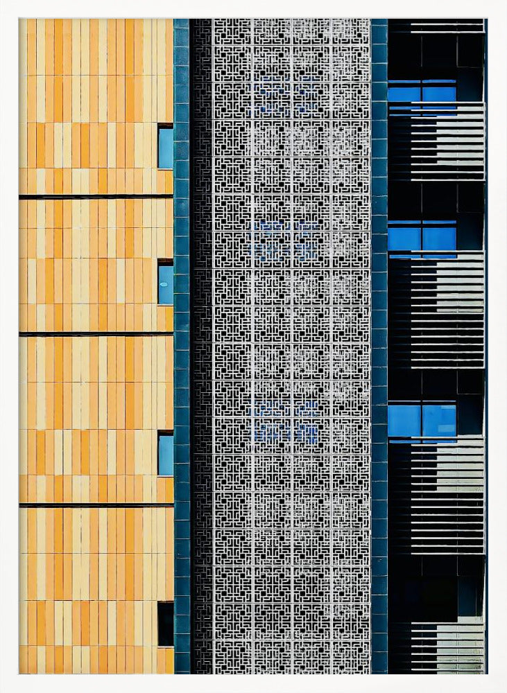 A vertical abstract architectural photograph showcasing the facade of a modern building, featuring a contrast of textures and colors: warm yellow vertical tiles on the left, an intricate white geometric screen in the center, and a dark section with vibrant blue windows on the right. Print