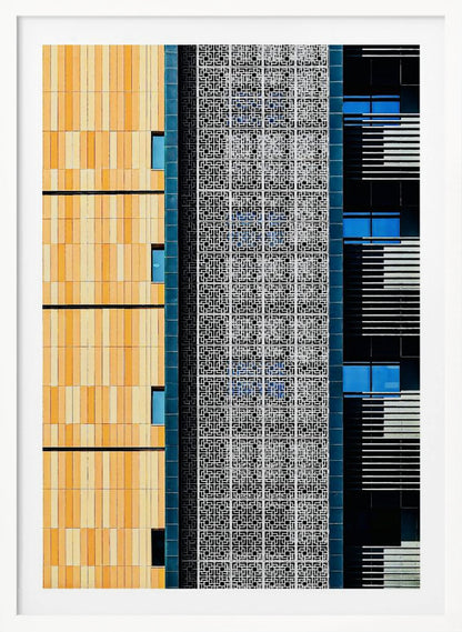 A vertical abstract architectural photograph showcasing the facade of a modern building, featuring a contrast of textures and colors: warm yellow vertical tiles on the left, an intricate white geometric screen in the center, and a dark section with vibrant blue windows on the right. Print