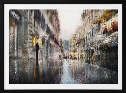 An impressionistic painting of a city street on a rainy day, viewed as if through a window covered in water droplets. The scene is blurred and atmospheric, with the wet pavement reflecting the muted colors of the buildings and distant figures. The artwork is presented in a silver frame. Decor