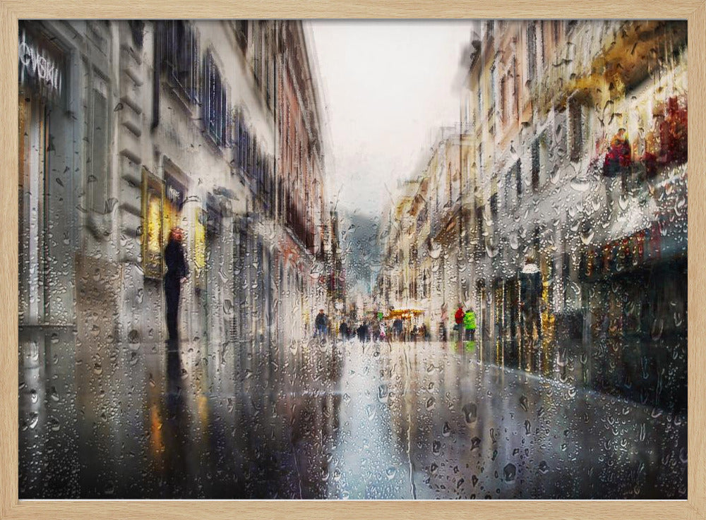 An impressionistic painting of a city street on a rainy day, viewed as if through a window covered in water droplets. The scene is blurred and atmospheric, with the wet pavement reflecting the muted colors of the buildings and distant figures. The artwork is presented in a silver frame. Decor