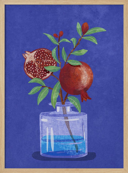 A vibrant illustration of a pomegranate branch in a clear glass vase against a deep blue, textured background. The branch features bright green leaves, a whole red pomegranate, and another cut in half to show its seeds. Decor