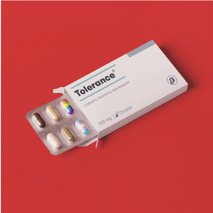 A framed conceptual art piece on a bright red background. It features a white medicine box labeled 'Tolerance', with a blister pack of pills emerging. Most pills are in various skin tones, but one is a rainbow pride flag and another is a transgender pride flag. Artwork