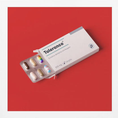 A framed conceptual art piece on a bright red background. It features a white medicine box labeled 'Tolerance', with a blister pack of pills emerging. Most pills are in various skin tones, but one is a rainbow pride flag and another is a transgender pride flag. Artwork
