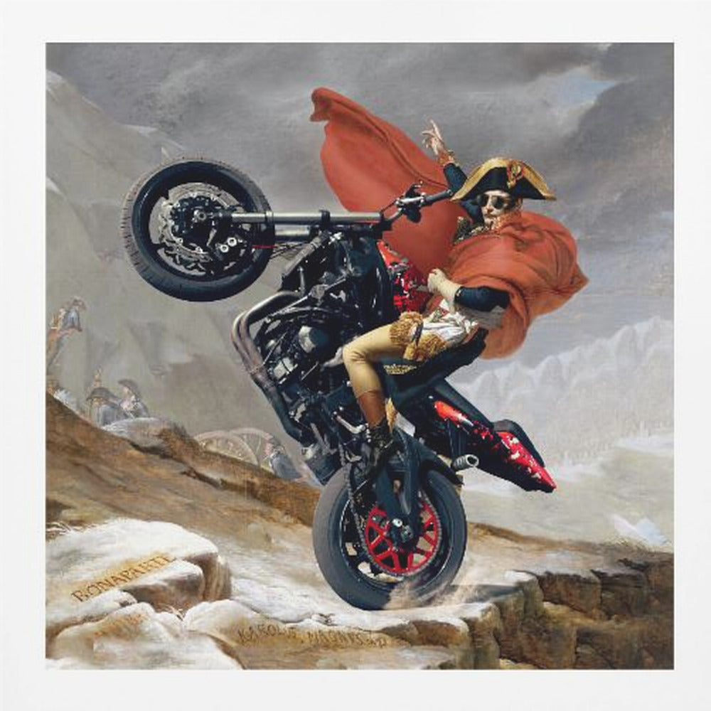 A framed parody artwork of the classic painting 'Napoleon Crossing the Alps.' Instead of a horse, Napoleon Bonaparte is performing a dramatic wheelie on a modern black and red motorcycle. He wears sunglasses, his signature bicorne hat, and a flowing red cape against a snowy, mountainous backdrop. Print