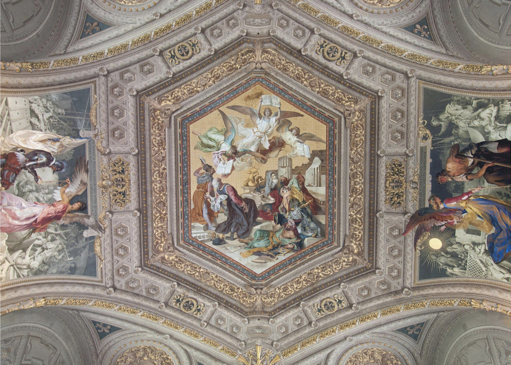 A detailed photograph of an ornate, coffered ceiling from the Renaissance period. The ceiling has intricate grey and gold architectural details, with a central hexagonal fresco and smaller side paintings depicting religious scenes with angels and figures in classical robes, all enclosed in a silver frame. Artwork