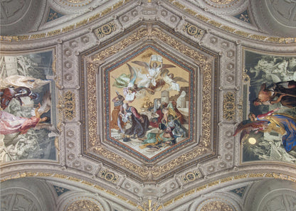 A detailed photograph of an ornate, coffered ceiling from the Renaissance period. The ceiling has intricate grey and gold architectural details, with a central hexagonal fresco and smaller side paintings depicting religious scenes with angels and figures in classical robes, all enclosed in a silver frame. Artwork