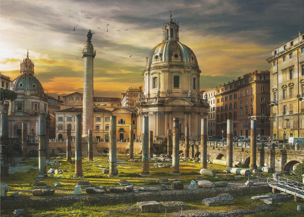 A framed photograph of Trajan's Forum in Rome, Italy, during a dramatic sunset. The foreground is filled with ancient stone columns and ruins on a grassy field, leading to the prominent Trajan's Column and the domed Church of the Most Holy Name of Mary against a golden and dark cloudy sky. Wall Art