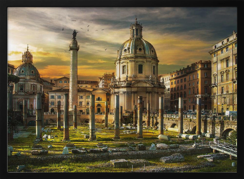 A framed photograph of Trajan's Forum in Rome, Italy, during a dramatic sunset. The foreground is filled with ancient stone columns and ruins on a grassy field, leading to the prominent Trajan's Column and the domed Church of the Most Holy Name of Mary against a golden and dark cloudy sky. Wall Art