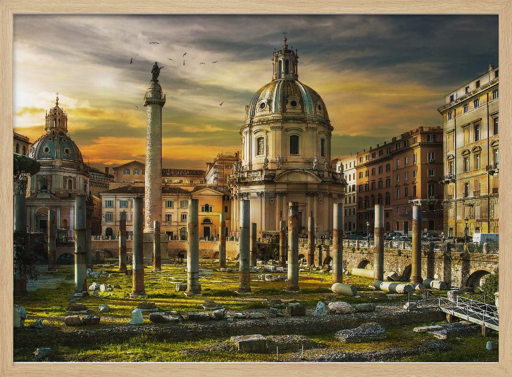 A framed photograph of Trajan's Forum in Rome, Italy, during a dramatic sunset. The foreground is filled with ancient stone columns and ruins on a grassy field, leading to the prominent Trajan's Column and the domed Church of the Most Holy Name of Mary against a golden and dark cloudy sky. Wall Art