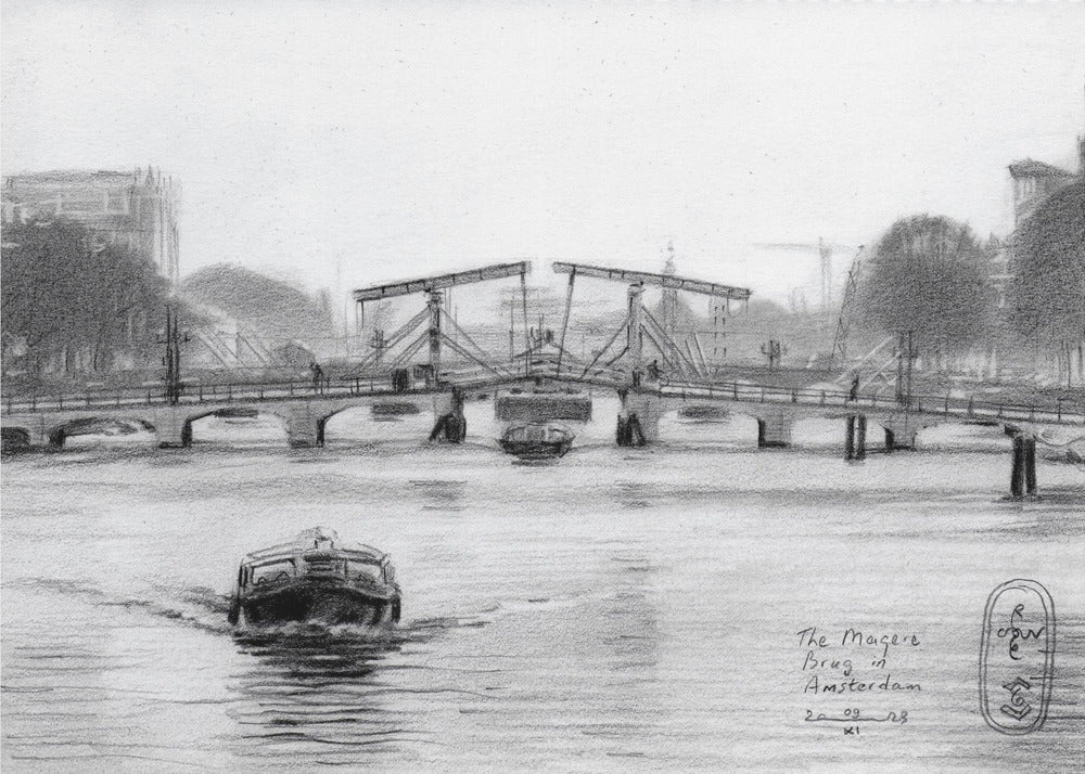 A framed black and white pencil drawing of the Magere Brug, a famous bridge in Amsterdam. The drawbridge is depicted over a canal with a boat in the foreground, creating a classic European city scene. Wall Art