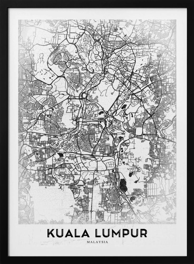 A minimalist black and white street map of Kuala Lumpur, displayed in a black frame. The map shows a detailed network of roads and city blocks on a textured white background. The name "KUALA LUMPUR" is printed in a bold, modern font at the bottom. Decor