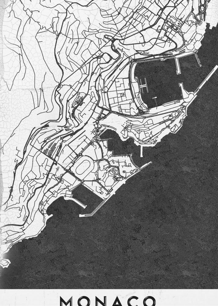A modern black and white map of Monaco, presented as a framed poster. The map details the city's streets and coastline in black lines on a white background, while the sea is depicted in a solid, textured black. The title 'MONACO' is at the bottom in a bold, white band. Poster