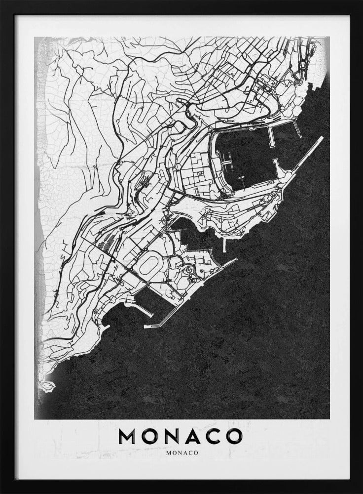 A modern black and white map of Monaco, presented as a framed poster. The map details the city's streets and coastline in black lines on a white background, while the sea is depicted in a solid, textured black. The title 'MONACO' is at the bottom in a bold, white band. Poster