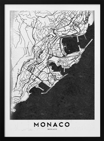 A modern black and white map of Monaco, presented as a framed poster. The map details the city's streets and coastline in black lines on a white background, while the sea is depicted in a solid, textured black. The title 'MONACO' is at the bottom in a bold, white band. Poster