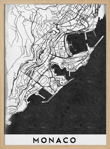 A modern black and white map of Monaco, presented as a framed poster. The map details the city's streets and coastline in black lines on a white background, while the sea is depicted in a solid, textured black. The title 'MONACO' is at the bottom in a bold, white band. Poster