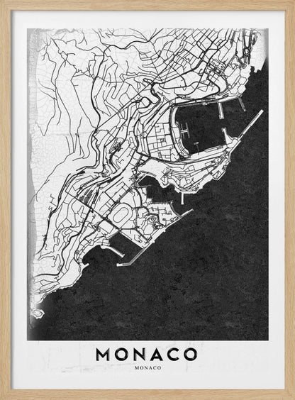 A modern black and white map of Monaco, presented as a framed poster. The map details the city's streets and coastline in black lines on a white background, while the sea is depicted in a solid, textured black. The title 'MONACO' is at the bottom in a bold, white band. Poster