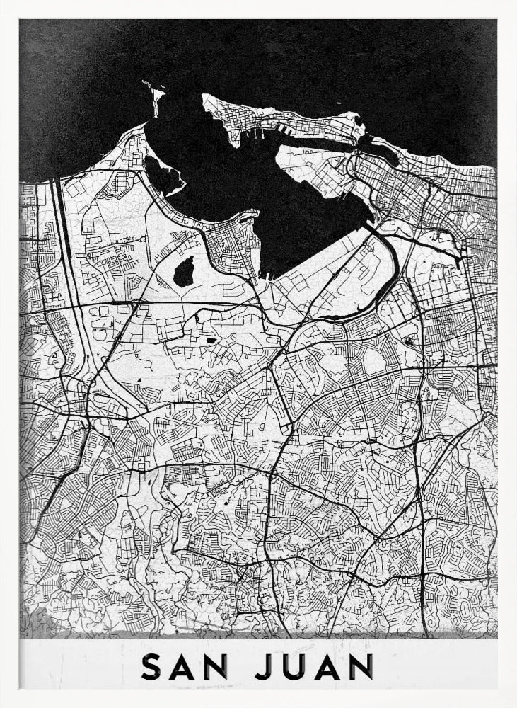 A minimalist black and white map of San Juan, Puerto Rico, shown as a framed poster. The land is depicted in white with intricate black lines for roads and streets, while the surrounding water is a solid, textured black. A white banner at the bottom features the text 'SAN JUAN' in a bold, black, sans-serif font. Artwork