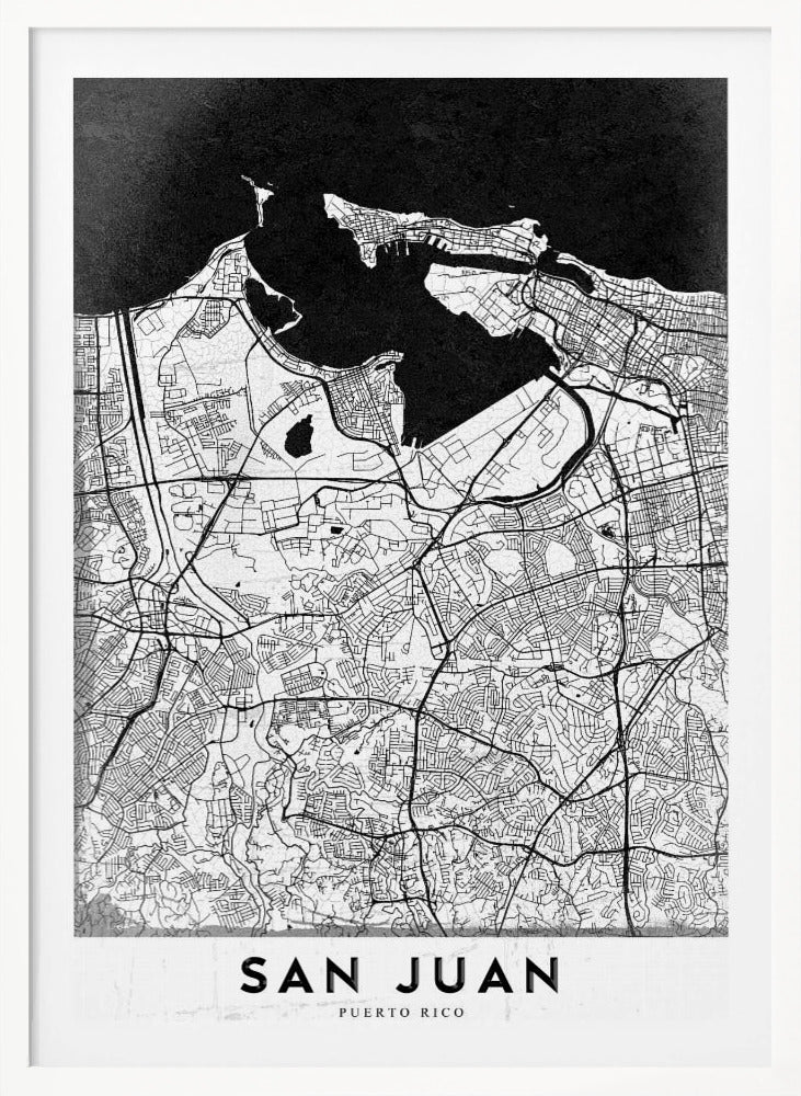 A minimalist black and white map of San Juan, Puerto Rico, shown as a framed poster. The land is depicted in white with intricate black lines for roads and streets, while the surrounding water is a solid, textured black. A white banner at the bottom features the text 'SAN JUAN' in a bold, black, sans-serif font. Artwork