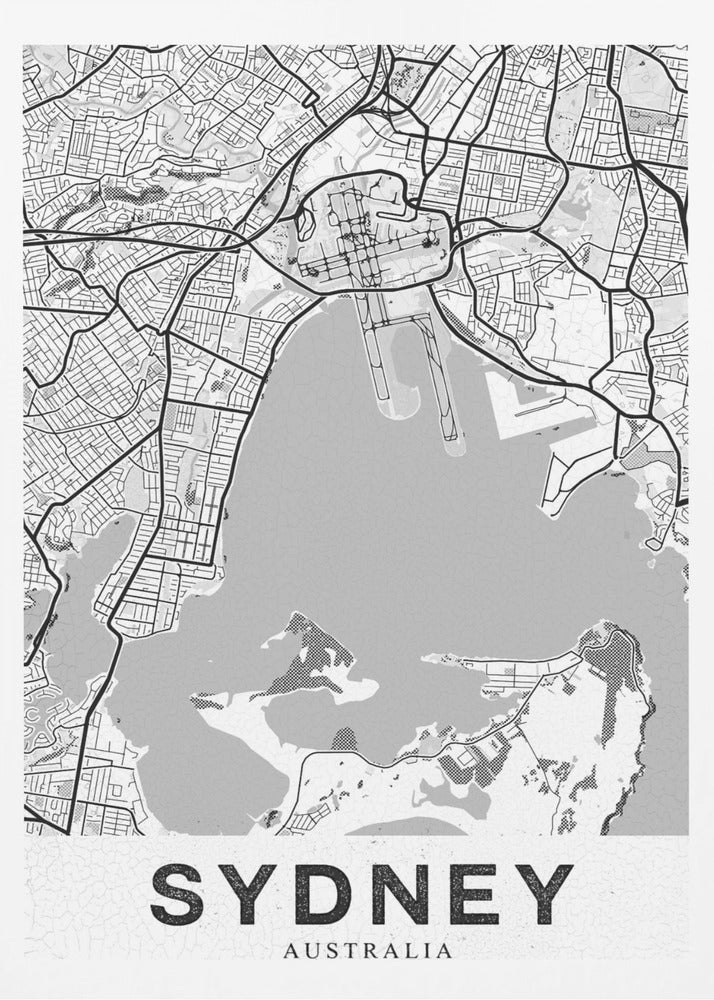 A modern, black and white framed art print of a stylized map of Sydney, Australia. The map features bold black lines for the street grid and major roads, with light grey for the landmass and a darker grey for the water of the harbor. The word 'SYDNEY' is printed in large, black, sans-serif font at the bottom of the poster. Poster