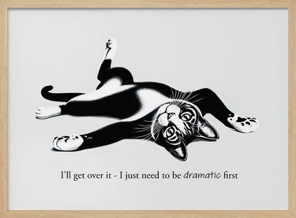 A framed black and white illustration of a tuxedo cat lying playfully on its back. Below the image is the text, 'I'll get over it - I just need to be dramatic first'. Artwork