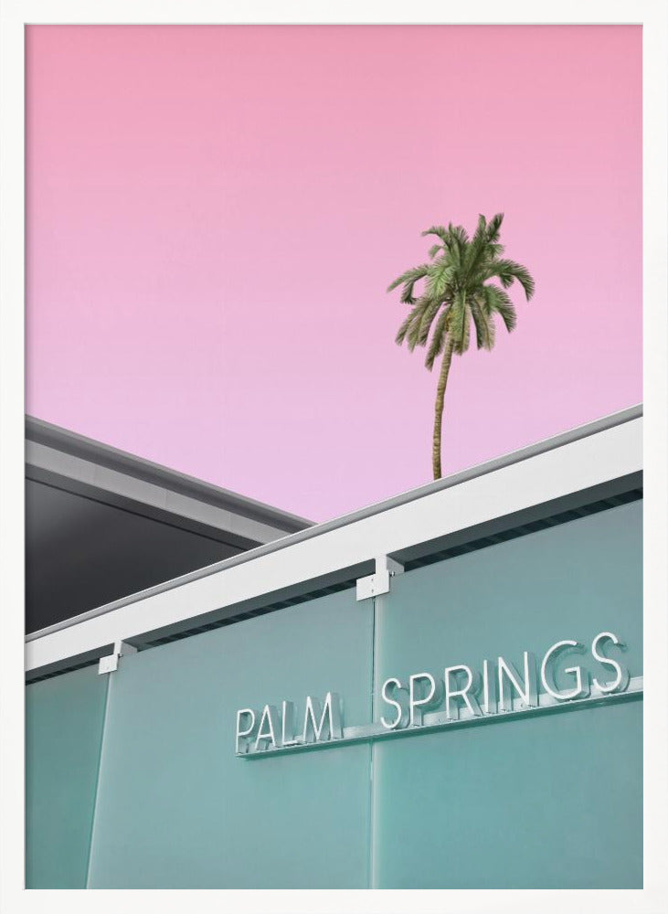 A low-angle shot of a modern building with a frosted teal glass facade and a white neon sign that reads 'PALM SPRINGS'. Above the building, a single tall palm tree stands against a solid, vibrant pink sky, creating a minimalist and stylized composition. Decor