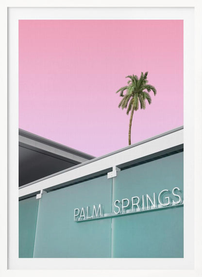 A low-angle shot of a modern building with a frosted teal glass facade and a white neon sign that reads 'PALM SPRINGS'. Above the building, a single tall palm tree stands against a solid, vibrant pink sky, creating a minimalist and stylized composition. Decor