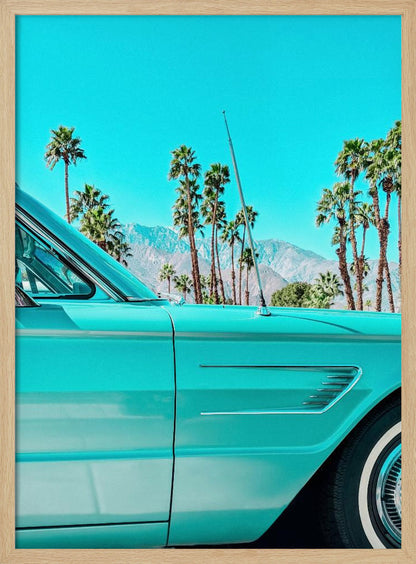 A vibrant, stylized photograph of a vintage turquoise car parked under a clear blue sky, with a row of tall palm trees and distant mountains creating a classic, sunny California scene. Wall Art