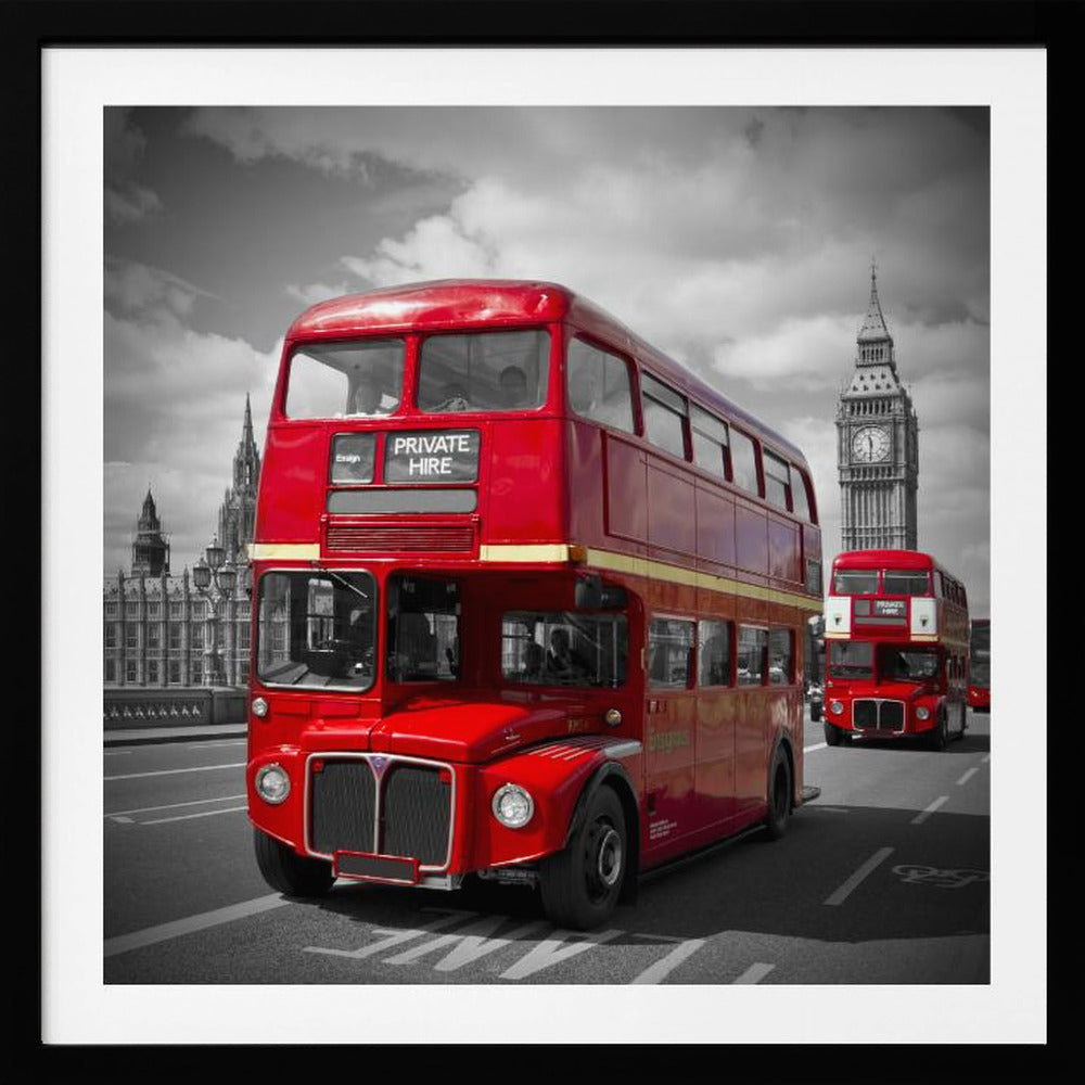 A framed, selective color photograph of a bright red, vintage double-decker bus on a bridge in London. The background, including the Big Ben clock tower, is in black and white, making the red bus stand out. Artwork